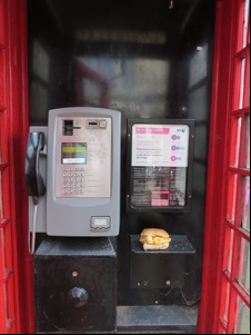 Red phone box containing a brown Quavers roll
