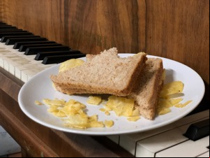 Bitten brown bread crisp sandwich on a piano