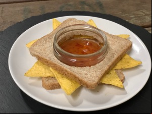 Doritos in brown bread with hole for jar of dip