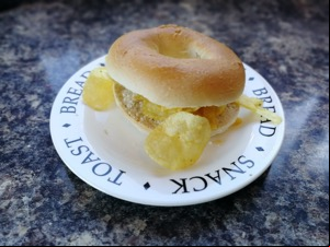 Crisp-overfilled bagel on a typographic plate