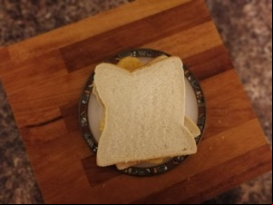 Overhead view of white crisp sandwich on chopping board