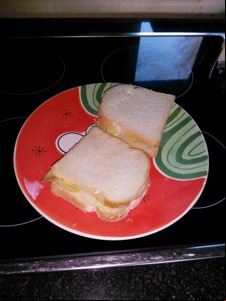 Two sandwiches of sliced white bread with crisps