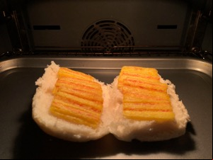Frazzles on an open white roll in an oven