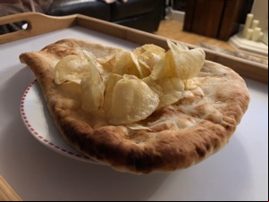 Potato crisps laid on a whole naan bread