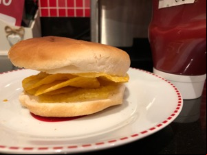 Buttered white roll containing potato crisps