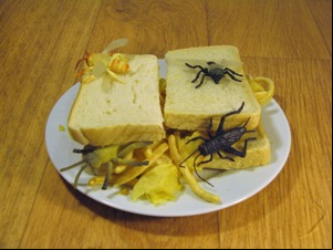 Halved sandwich covered with plastic insects