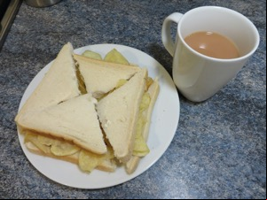 White crisp sandwich alongside a mug of tea
