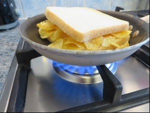 White crisp sandwich in a pan on a gas hob